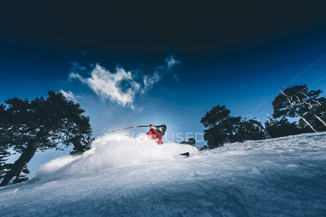 Uomo che pratica lo sci di velocità sul pendio sotto il cielo blu — Foto stock
