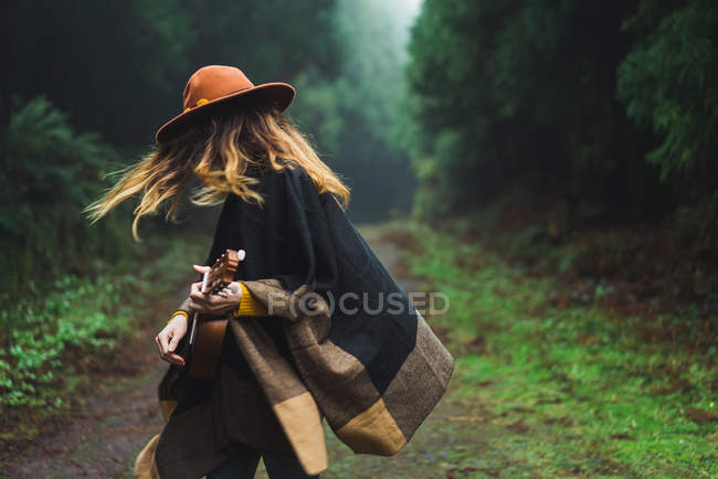 Mulher expressiva jogando ukulele na natureza — Fotografia de Stock
