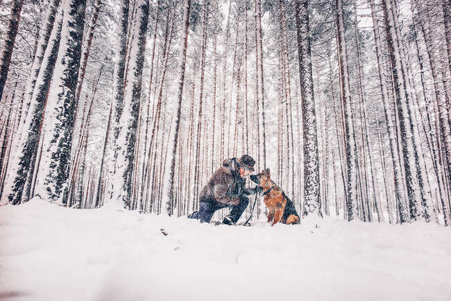 Uomo affettuoso con cane nella foresta. — Foto stock