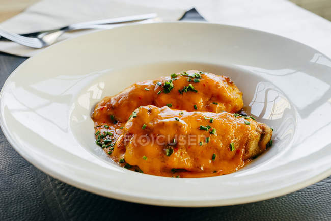 Фаршированный перец с соусом на белой тарелке — стоковое фото
