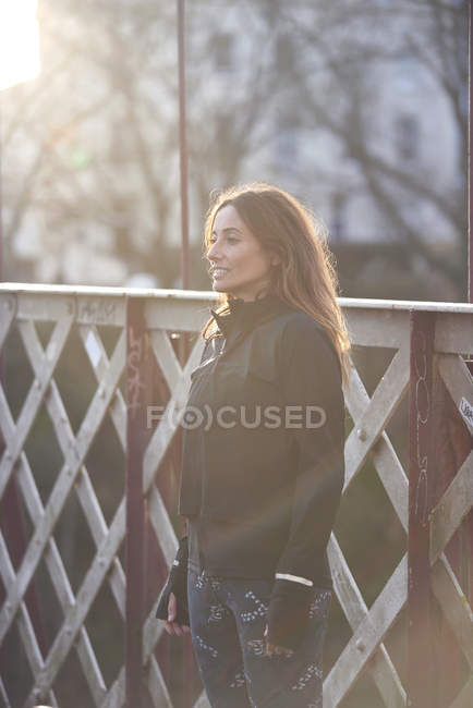 Brunette woman standing by plank fence — Stock Photo