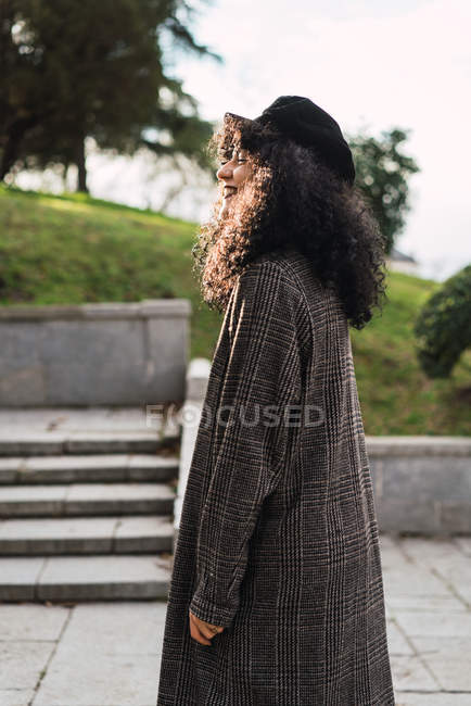 Lächelnde stilvolle Frau, die im Park spaziert — Stockfoto