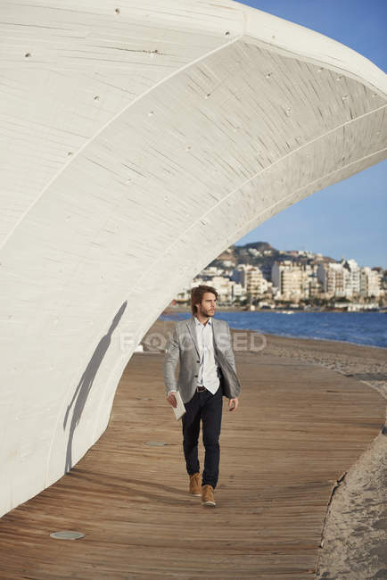 Empresario caminando en callejón además del mar - foto de stock