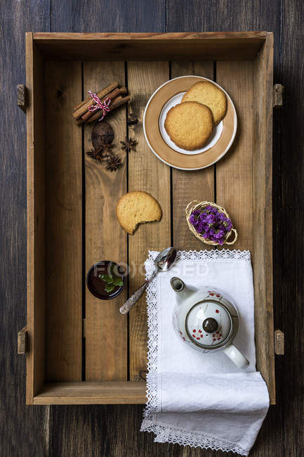 Théière en céramique avec tasse de thé vert et biscuits sur plateau en bois — Photo de stock