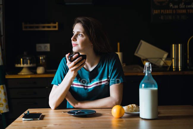 Charming woman having breakfast and looking aside — Stock Photo