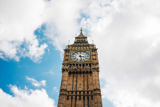 De baixo da visão do belo monumento arquitetônico de Big Ben contra o céu azul com nuvens. — Fotografia de Stock