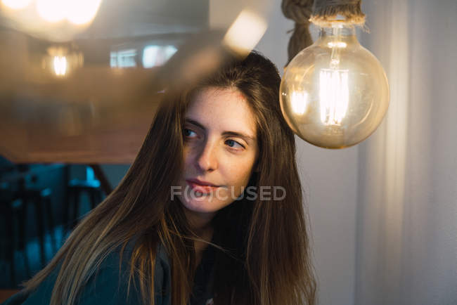 Donna posa vicino lampadina — Foto stock