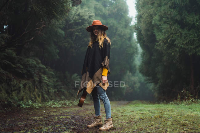 Charming woman posing with ukulele in nature — Stock Photo