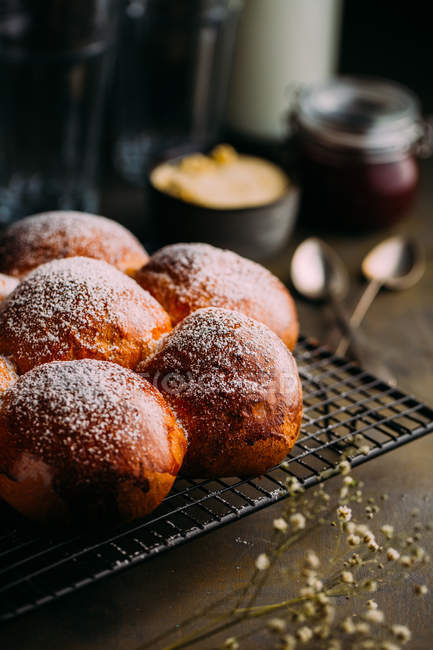 Close up view of brioche with icing sugar with butter and jam at background — Stock Photo