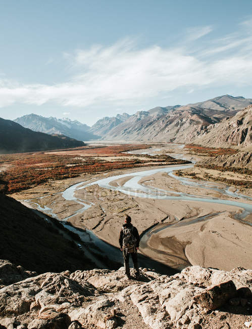 Vue arrière du touriste debout sur la roche à la vallée de la rivière — Photo de stock
