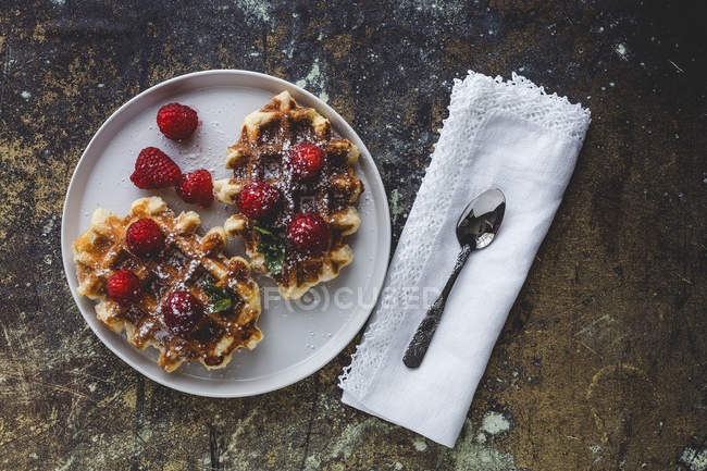 Waffle with cream raspberries and chocolate strawberries on plate — Stock Photo