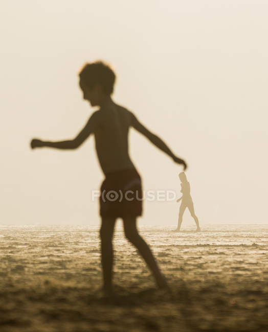 Silhouette di bambino e persona irriconoscibile che camminano nella tempesta di sabbia
. — Foto stock