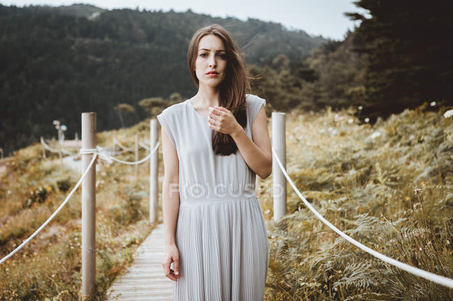 Zarte brünette Frau im Kleid posiert auf der Natur — Stockfoto