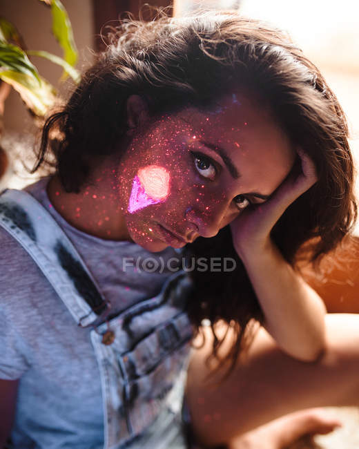 Woman with ice-cream painted with luminous paint on face — Stock Photo