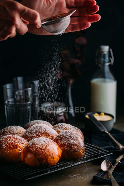 Crop hands icing brioche on tray at table — Stock Photo