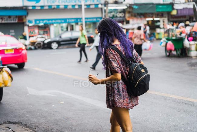 Mujer joven bonita con el pelo morado caminando por la calle - foto de stock