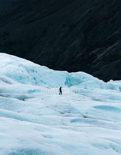 Vista à distância do turista em pé na colina nevada — Fotografia de Stock