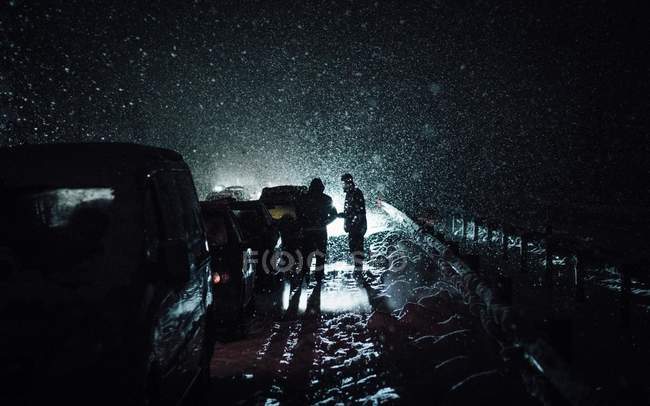 Autos stecken nachts im Schnee fest — Stockfoto