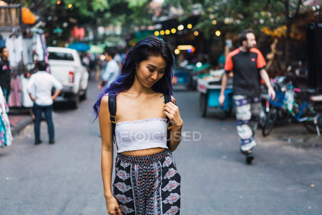 Donna allegra con i capelli viola che cammina sulla strada — Foto stock