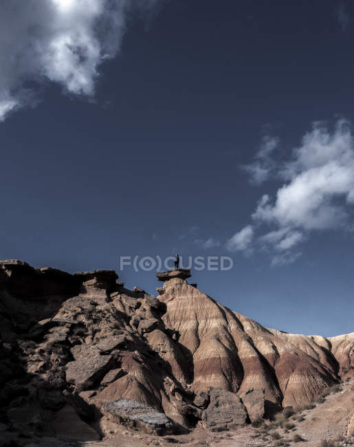 Turista irriconoscibile in piedi sulla cima della collina alla luce del giorno . — Foto stock