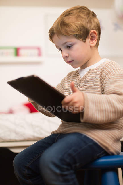 Portrait of blonde boy playing with tablet — Stock Photo