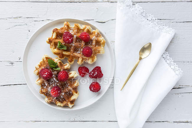 Directly above homemade waffle with cream raspberries and chocolate strawberries on white table — Stock Photo