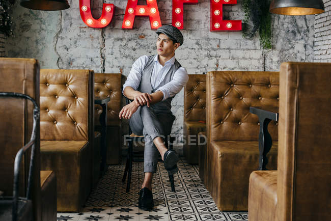 Hombre soñando despierto en ropa vintage sentado en la cafetería - foto de stock