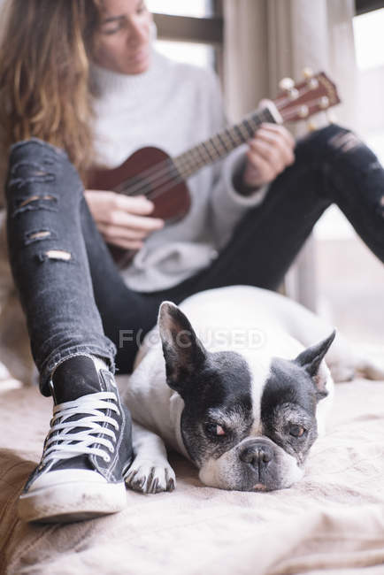 Mujer y perro relajándose en casa - foto de stock