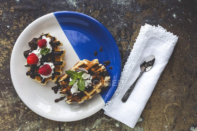 Вафелька з вершковою малиною та шоколадною полуницею на тарілці — стокове фото