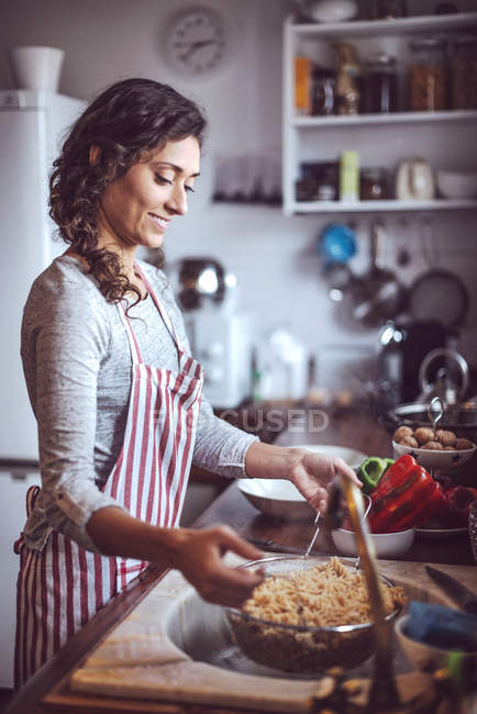 Vue latérale de la femme souriante à la cuisine — Photo de stock