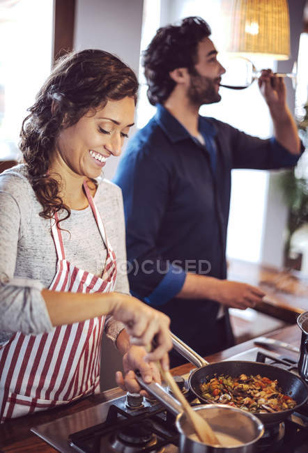 Vista lateral de pareja joven cocinando juntos en la cocina - foto de stock