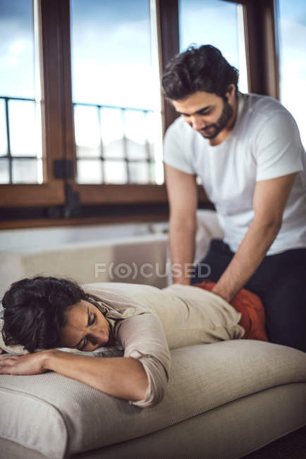 Homem massageando mulher no treinador em casa — Fotografia de Stock