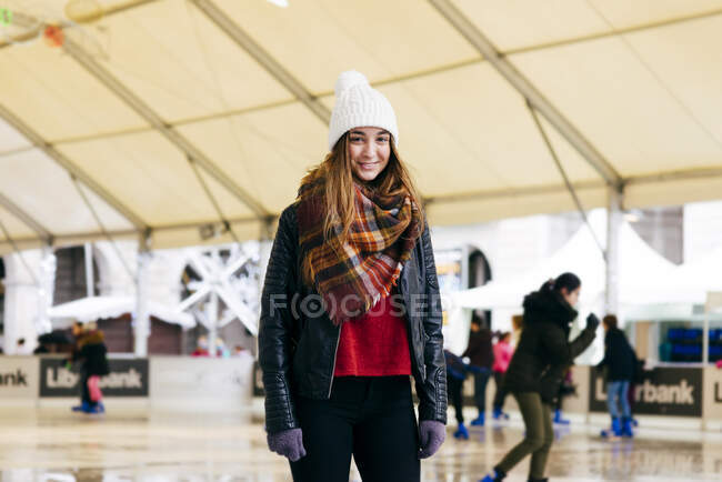 Femme souriante debout sur la patinoire — Photo de stock