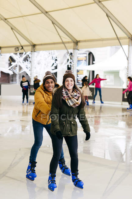 Couple joyeux s'amuser sur la patinoire — Photo de stock