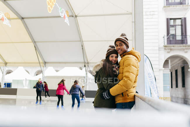 Allegro coppia abbracciato su pista di pattinaggio — Foto stock