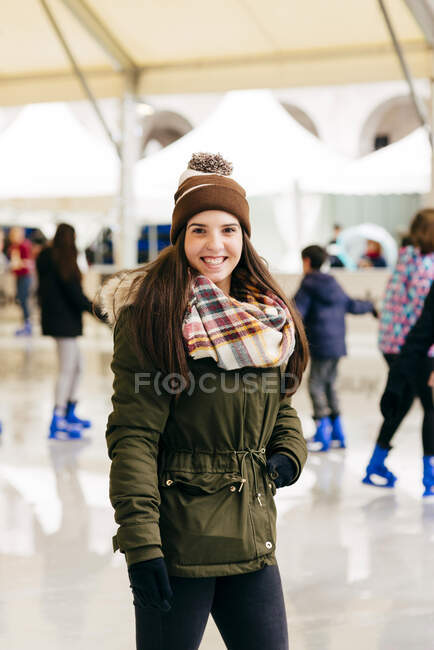 Lächelnde Frau steht auf Eisbahn — Stockfoto