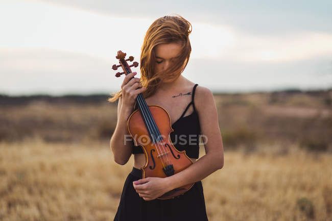 Bella donna in posa con violino sul campo — Foto stock