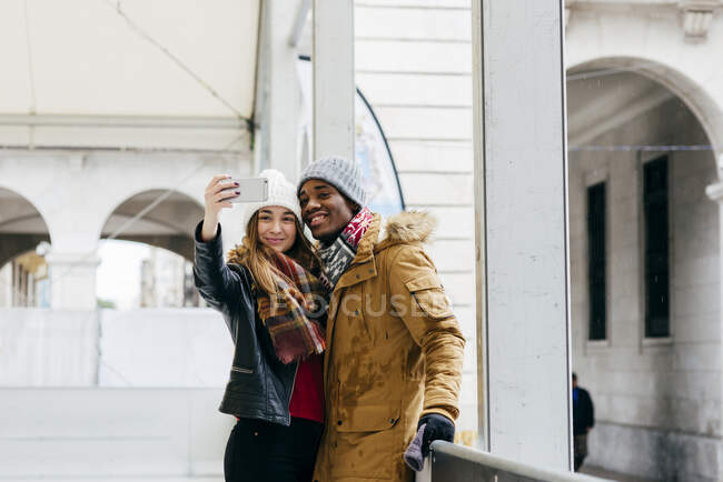 Allegro coppia prendendo selfie su pista di pattinaggio — Foto stock