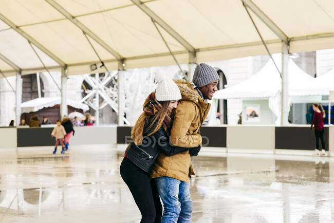 Cheerful couple embraced on rink — Stock Photo
