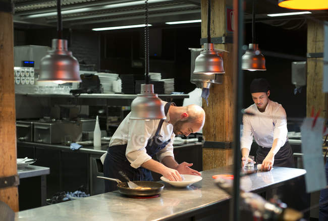 Köche bereiten Gerichte in Restaurantküche zu — Stockfoto