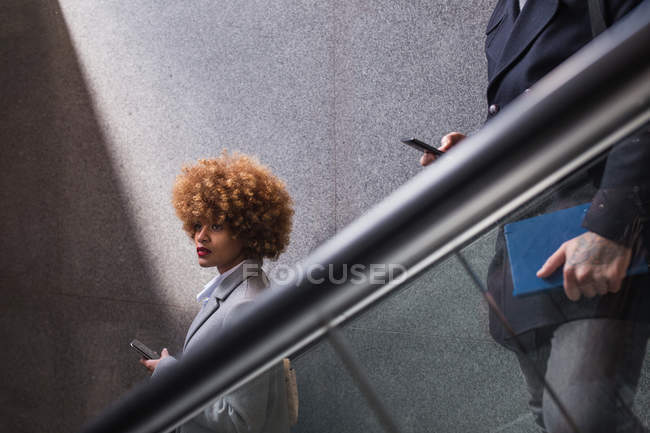 Cropped image of couple with phone in hands on escalator — Stock Photo