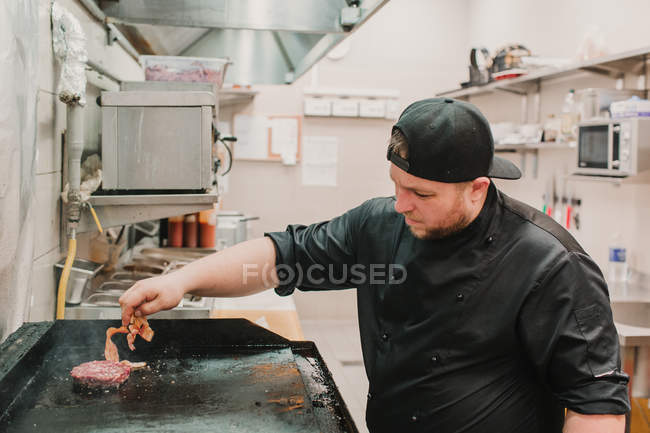 Шеф-повар поворачивает и готовит пирожки на кухне ресторана — стоковое фото