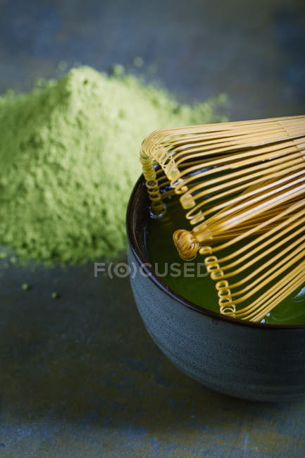 Бамбуковый венчик на миске за кучей маття — стоковое фото