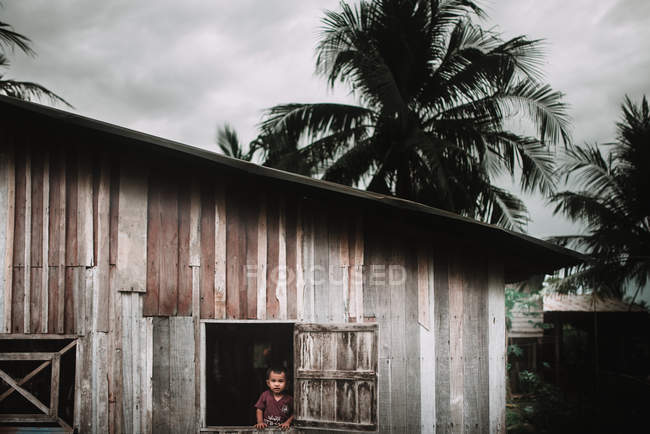 LAOS, 4000 ÎLES : Petit garçon regardant par la fenêtre — Photo de stock