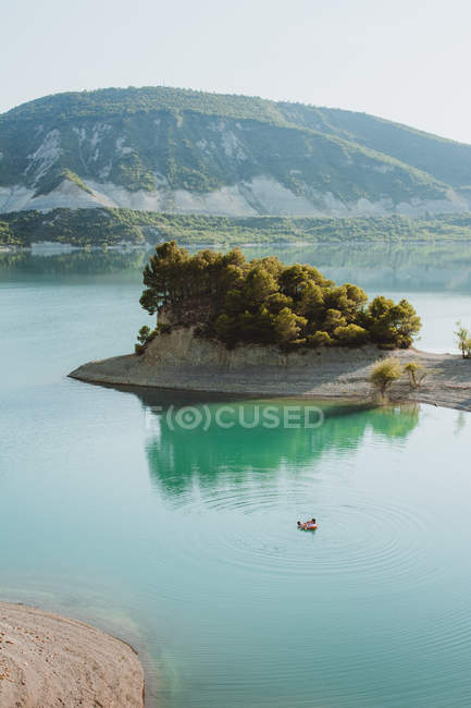Aerial view of small boat floating in turquoise water of mountain lake. — Stock Photo