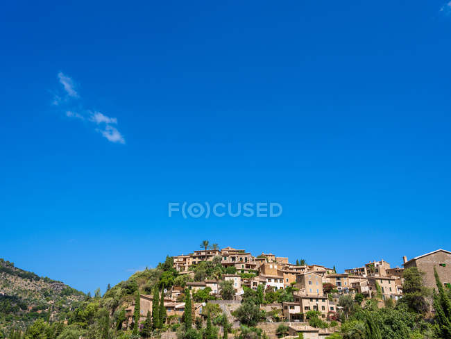 Small houses on mountain over bright sky. — Stock Photo