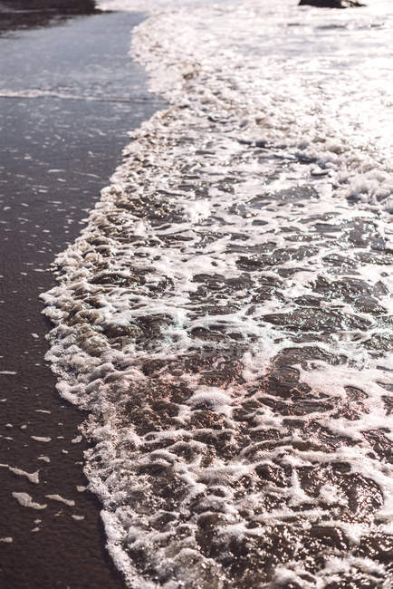 Rochers dans le surf vagues de mer à terre en plein jour — Photo de stock
