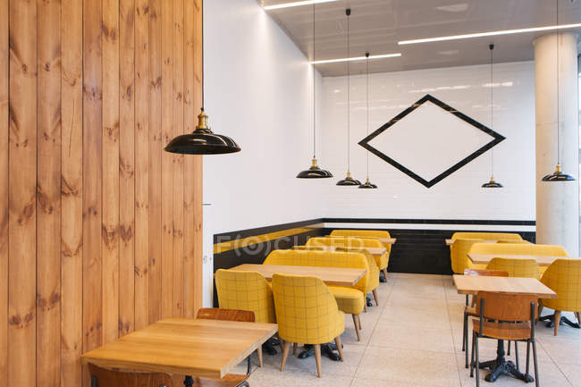 Interior view of empty tables and yellow chairs in cafe — Stock Photo