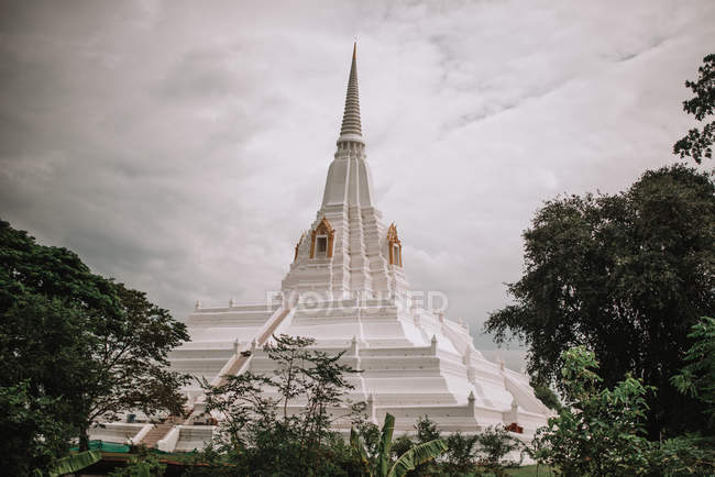 View to big spire of white traditional pagoda in gray cloudy day. — Stock Photo