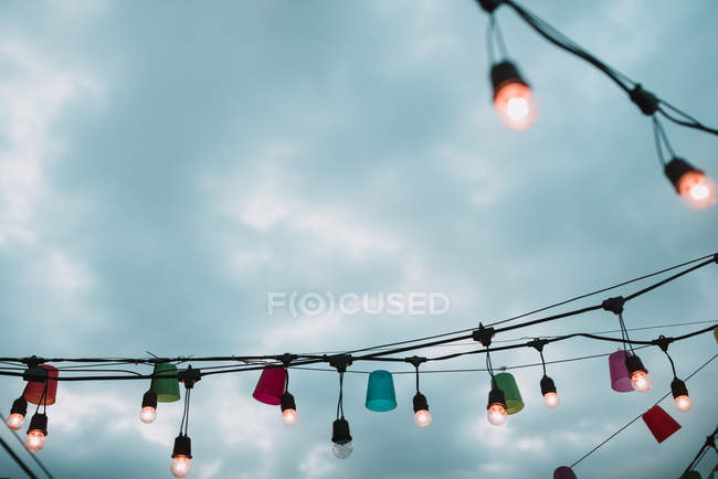 Luces coloridas en la aldea sobre el cielo dramático - foto de stock